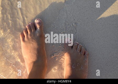 Young child's sandy feet on the beach