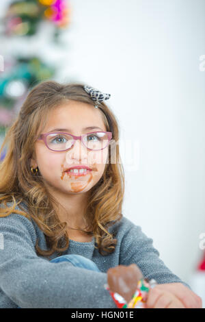 Girl eating chocolate, mouth in a mess Stock Photo