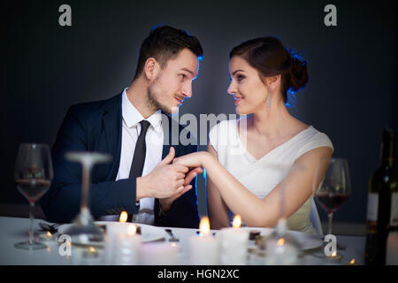 Man holding girlfriends hand at dinner Stock Photo