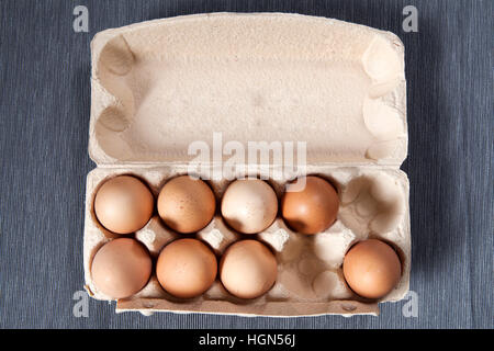 Eggs from market in plastic package on the gray napkin. Top view. The box is not full. Stock Photo