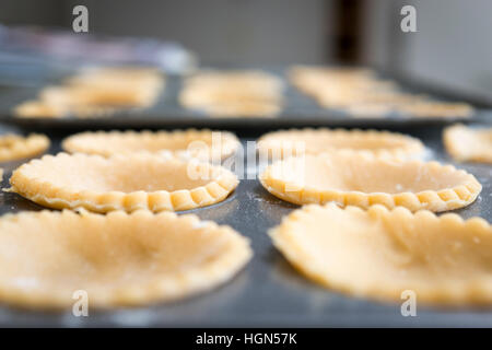 Home made mince pie pastry cases in a baking tin ready to be filled with mincemeat Stock Photo
