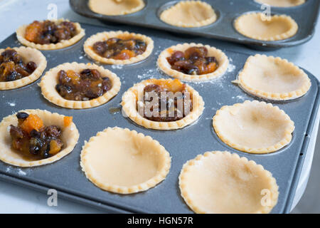 Homemade mince pies. Pastry cases filled with mincemeat ready to go in the oven Stock Photo