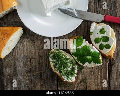 Tasty bruschetta with creamy cheese on wooden board Stock Photo - Alamy