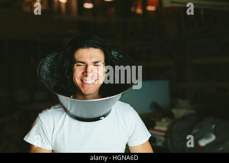 Male model wearing fooling around his neck Studio reflector diffuser. Dog Recovery Collar Cones Stock Photo