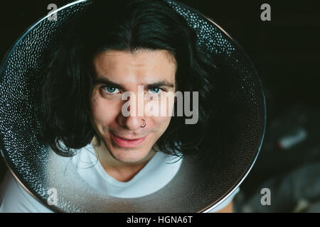 Male model wearing fooling around his neck Studio reflector diffuser. Dog Recovery Collar Cones Stock Photo