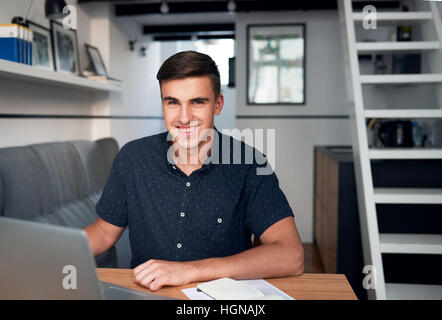 Handsome young man using a laptop at home Stock Photo