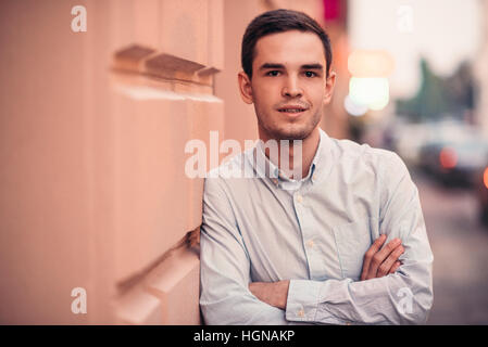 Confident young man standing on a city sidewalk Stock Photo