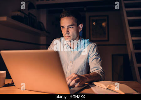 Young businessman working on a laptop late at night Stock Photo