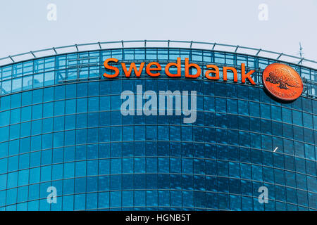 Riga, Latvia - June 30, 2016: Close View Of Blue Glass Building Facade Of Headquarter Of Swedbank With Red Signboard And Round Logotype On It. Stock Photo