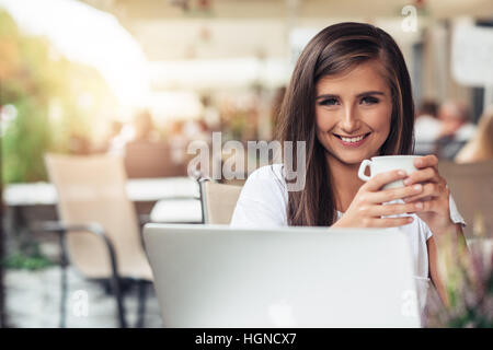 Young woman enjoying coffee at a cafe Stock Photo
