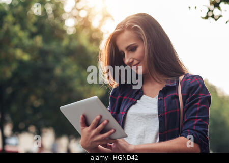 Young woman using a tablet while out in the city Stock Photo