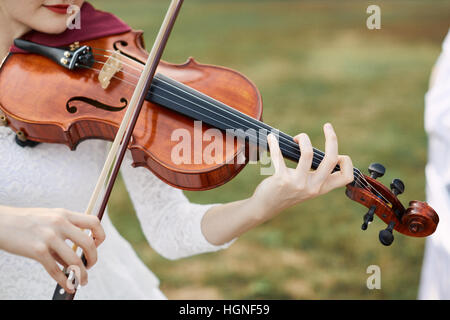 Violinist woman. Young woman playing a violin outside. Stock Photo
