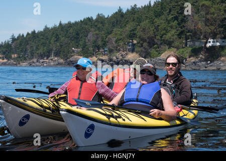 Kayakers on an eco-tour of the San Juan Islands, Washington, USA. Stock Photo