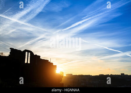 Destroyed an abandoned building on the blue sky background during sunset. Stock Photo