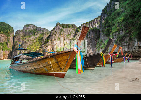 Thailand sea beach view round with steep limestone hills with many traditional longtail boats parking at Maya Bay, Ko Phi Phi Leh island, part of Krab Stock Photo