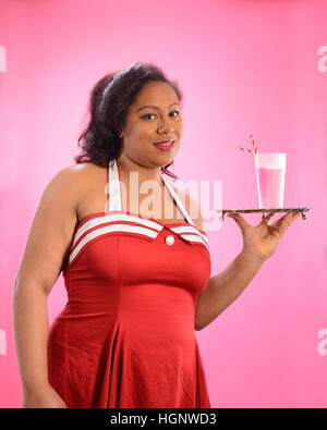 Pin up girl holding a silver tray with milkshake Stock Photo