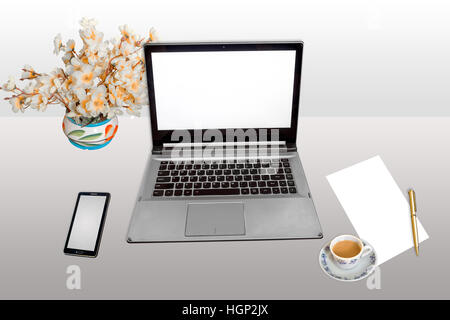 Workplace with laptop computer, smart phone, blank paper and pen with morning tea isolated. Stock Photo