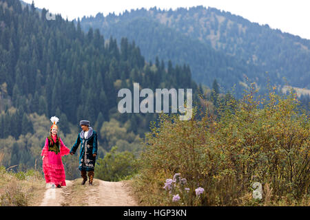 Kazakh couple in national costumes walking hand in hand, in Almaty, Kazakhstan Stock Photo