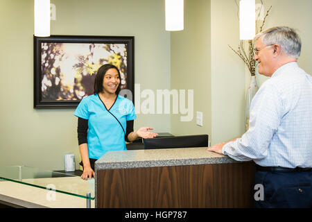 Patient checking into doctor's office Stock Photo