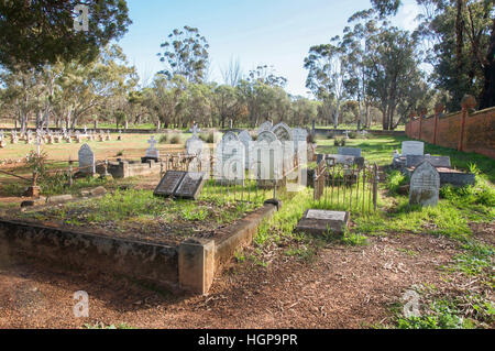 Gravestones with fences and markers in the treed landscape at the New Norcia cemetery in Western Australia. Stock Photo