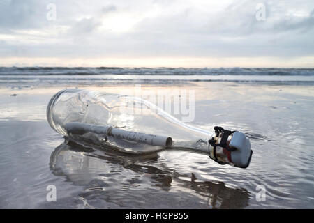 message in a bottle stranded on the beach Stock Photo