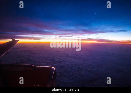 View of a sunrise from the window of an easyJet Airbus A320 plane over Europe, with the moon and an engine in view. Dawn. Space for copy