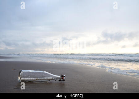 message in a bottle stranded on the beach Stock Photo