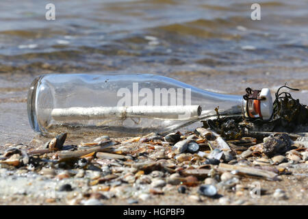 message in a bottle stranded on the beach Stock Photo