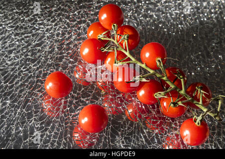 Ripe Fresh Cherry Tomatoes Branch on Broken Mirror Glass Stock Photo
