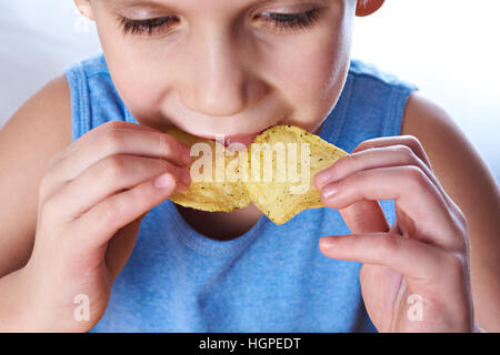 Little boy eating potato chips closeup Stock Photo