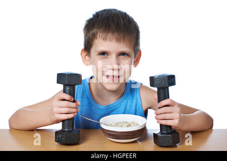 Boy eating porridge and dumbbells as symbols of sports lifestyle isolated white Stock Photo