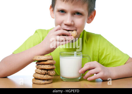 Little boy has breakfast cookies and milk isolated white Stock Photo