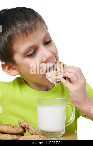 Little boy has breakfast cookies and milk isolated white Stock Photo