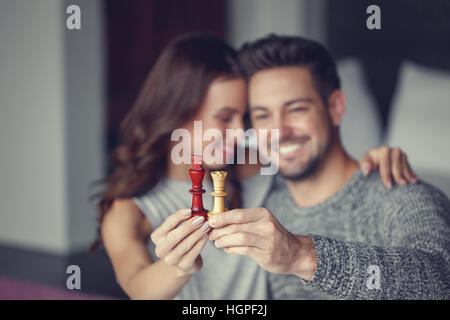 Happy couple holding chess figures, black king, white queen Stock Photo