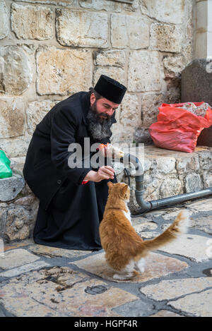 Pilgrim and cat in front of Holy Sepulcher church, Jerusalem, Israel. Stock Photo