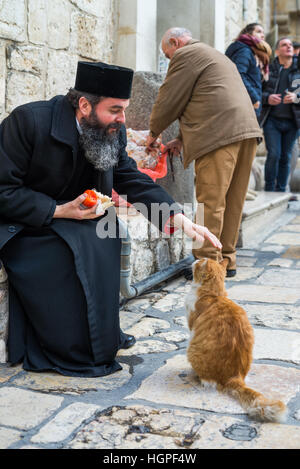 Pilgrim and cat in front of Holy Sepulcher church, Jerusalem, Israel. Stock Photo