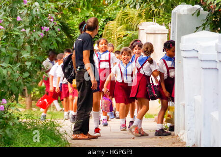 Schoolchildren in uniforms running to school in Havana, Cuba Stock Photo