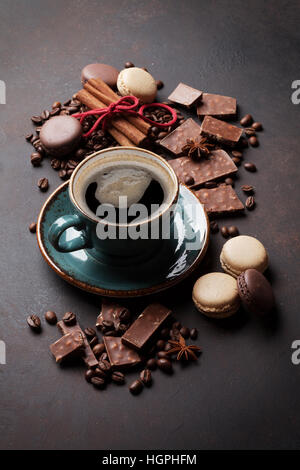 Coffee cup, beans, chocolate and macaroons on old kitchen table Stock Photo