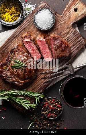 Grilled ribeye beef steak with red wine, herbs and spices. Top view Stock Photo