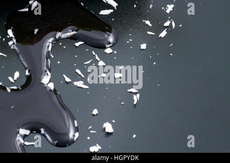 Sauce on black surface with coconut flakes Stock Photo