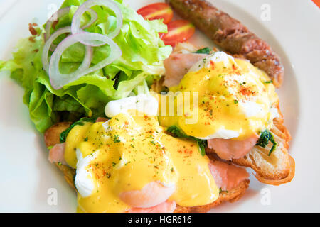 Egg benedict with smoked salmon, sauce, green salad vegetable and grill hot dog Stock Photo