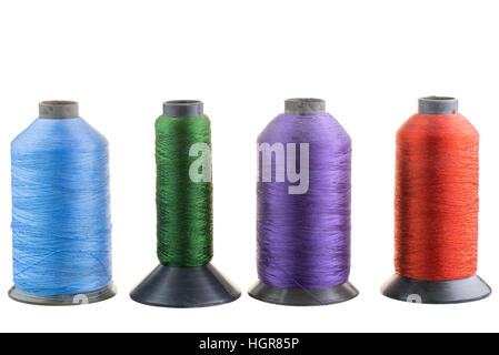 Four spools of silk thread in a row isolated Stock Photo