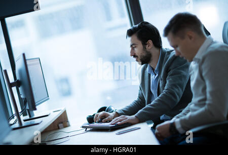 Software engineers developing applications together in office Stock Photo