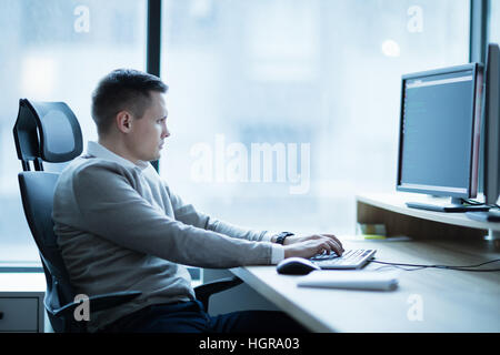 Software developer working on desktop on project in office Stock Photo