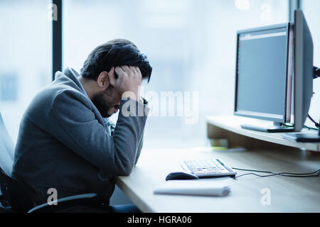 Depressed upset office worker having a headache problem and workplace crisis Stock Photo