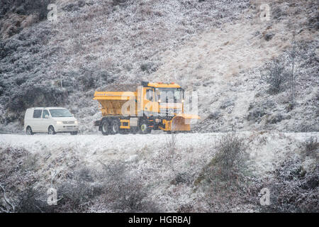 A snow plough clears the roads over the top of the Brecon Beacon's National Park on the A470 in Brecon, South Wales, where snow is settling. Stock Photo
