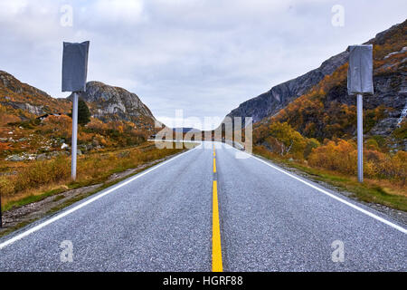 Route 45 in Rogaland, Norway, taking a sharp turn to the left, between autumn colored trees on the mountain sides Stock Photo