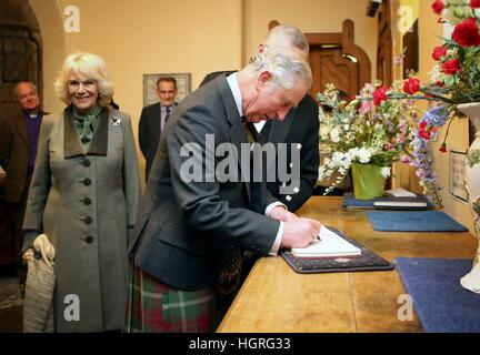 The Prince of Wales and the Duchess of Cornwall, known as the Duke and Duchess of Rothesay while in Scotland, sign the church visitors book before attending a performance of Robert Burns poetry with music by Professor Paul Mealor and the Aberdeen University Chamber Choir, at Glenmuick Church, Church Square, Ballater, Aberdeenshire. Stock Photo