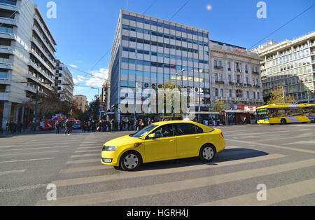 yellow taxi and people waiting to cross the road at Syntagma Athens Greece Stock Photo