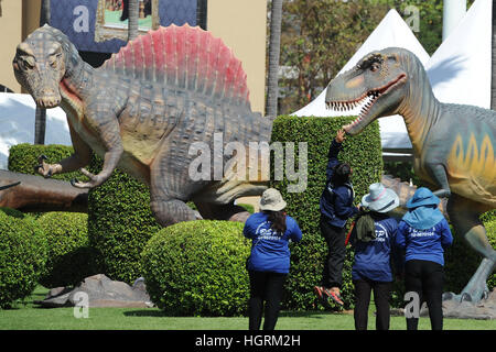 Bangkok, Thailand. 12th Jan, 2017. Workers look at dinosaur models in front of the Thai Government House in Bangkok, Thailand, Jan. 12, 2017. Life-size dinosaur models have been temporarily installed on the grounds of the Thai Government House ahead of the Thai Children's Day, when kids and parents are allowed to visit the building complex. © Rachen Sageamsak/Xinhua/Alamy Live News Stock Photo